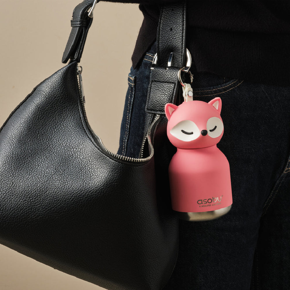 Pink fox-shaped keychain attached to a black handbag.