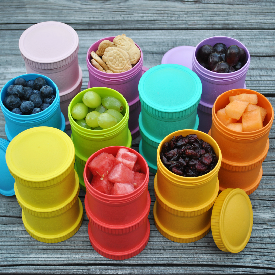 Re-Play Snack Stacks in different colours full of fruit and snacks. Lifestyle Image.